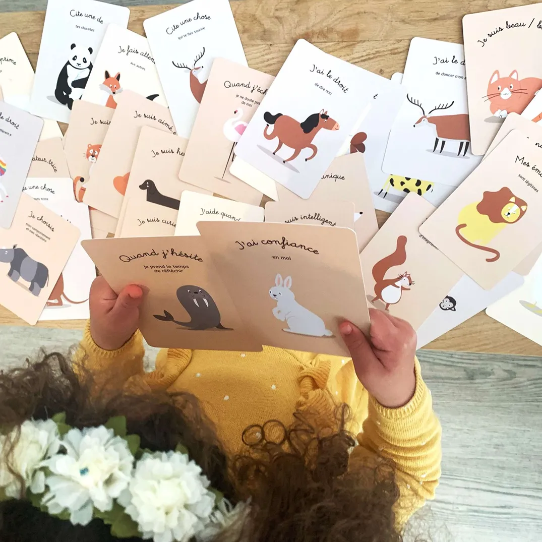 enfant qui porte des cartes d'affirmations positives, de confiance en soi dans ses mains