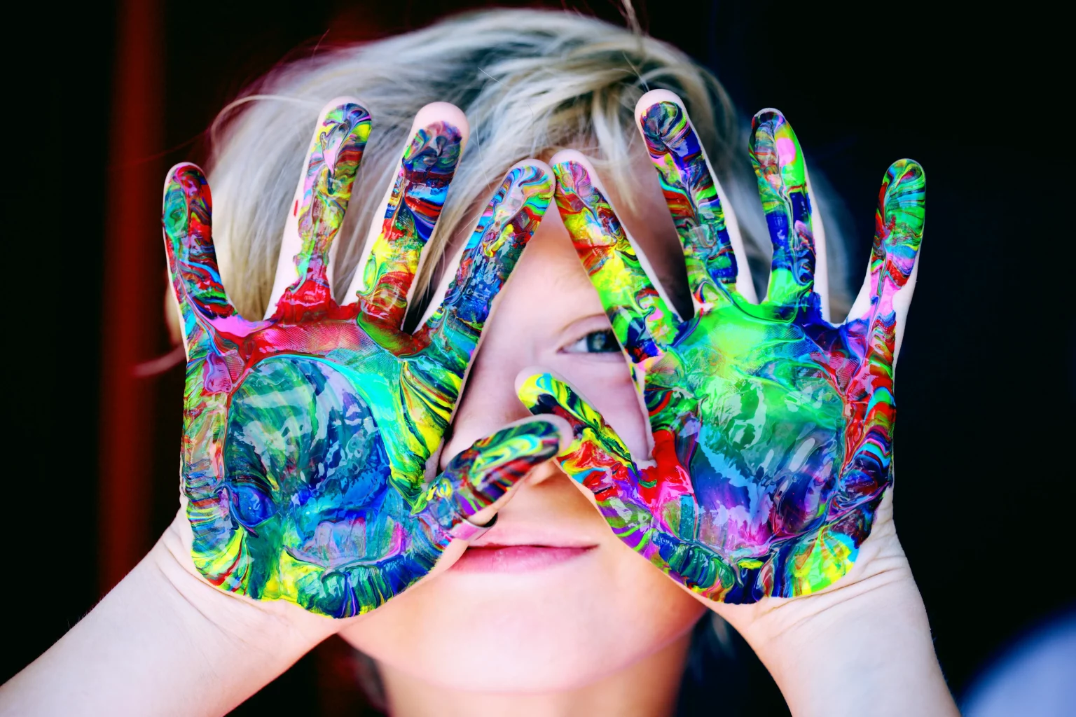 enfant avec les mains pleins de couleurs qui font références à toute la palette des émotions